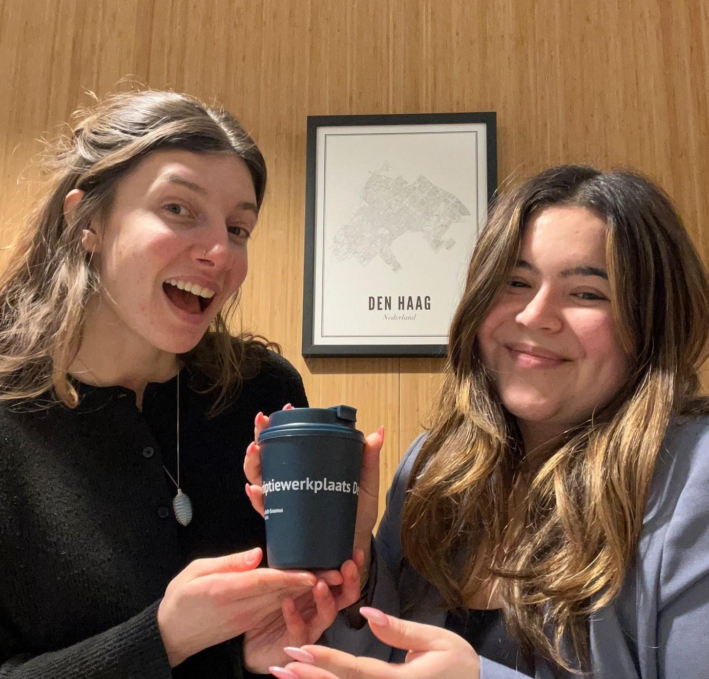 Two girls photo handing over coffeemug